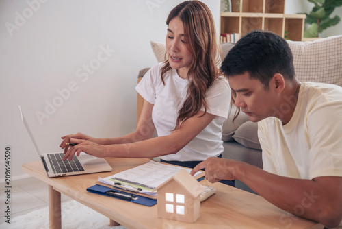 Couple lover make home financial plan. Young asian lover planning retire plan at home bedroom look at investment graph chart. Family finance investment happy together.