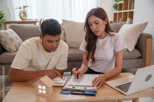Couple lover make home financial plan. Young asian lover planning retire plan at home bedroom look at investment graph chart. Family finance investment happy together.