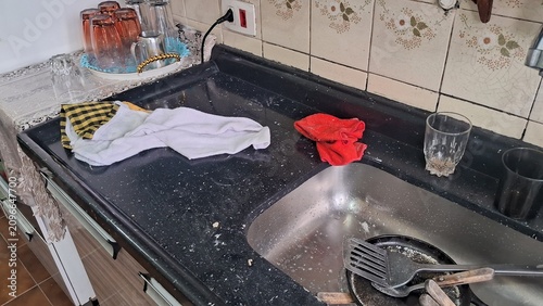 Tableau sur toile Messy kitchen counter with dirty dishes and scattered cleaning cloths