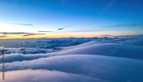 Aerial view of soft sunrise clouds over horizon.