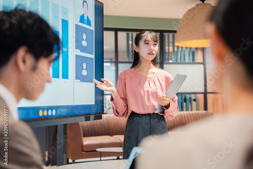 Foto オフィスでプレゼンをする若い女性