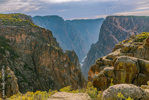 Tableau sur toile Gunnison River glints far below between massive dark canyon walls with pegmatite Painted Wall streaks, Black Canyon NP, Colorado