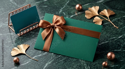 Elegant green gift envelope with copper ribbon on marble
