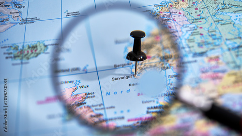 Bild auf Leinwand Magnifying glass over paper map marking Stavanger destination in Norway