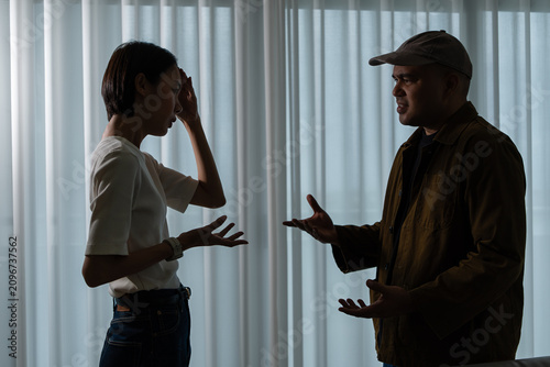 Schilderij op canvas Asian man and woman aggressively arguing in a dark room