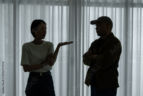 Fotografie Asian man and woman aggressively arguing in a dark room