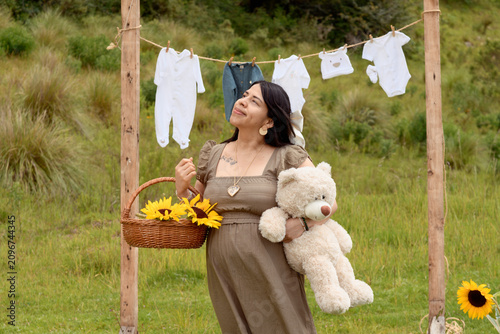 Pregnant Hispanic Woman Standing with Teddy Bear and Sunflower Basket