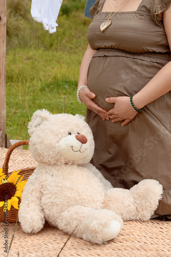 Close Up of Pregnant Hispanic Woman Making Heart Shape with Hands on Belly