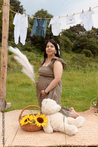 Full Shot of Pregnant Hispanic Woman Kneeling holding Pampas Grass in Meadow Setup