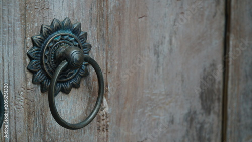 Obraz na plátně Side Angle View of Antique Brass Sunflower Door Knocker on Rustic Wood