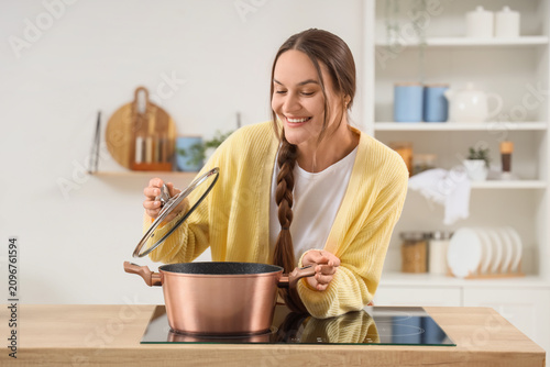 Smiling young woman cooking...