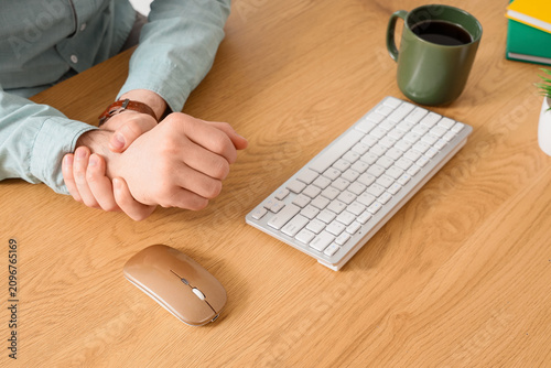 Foto Man experiencing wrist pain from prolonged computer use, carpal tunnel syndrome