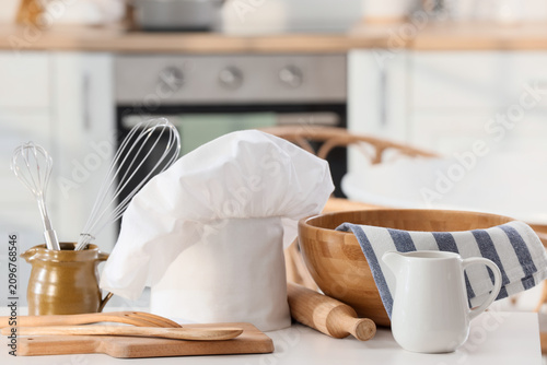 Chefs hat and utensils on w...