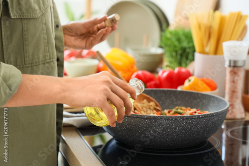 Young woman frying rice wit...