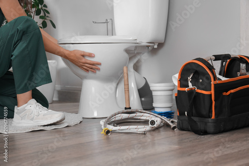Female plumber fixing toile...