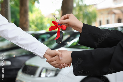 Woman giving gift keys of a...