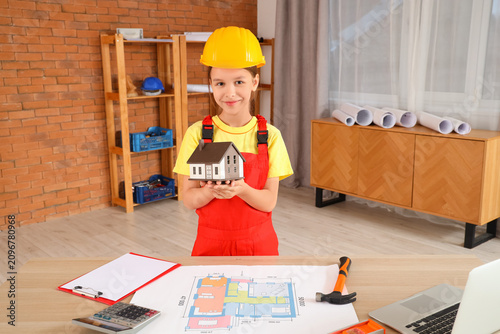 Little architect with house model in room