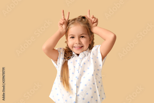 Happy little girl on beige ...