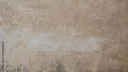 Close-up of a textured wall surface showing a mix of beige and off-white tones. The uneven finish adds depth and character to the background.