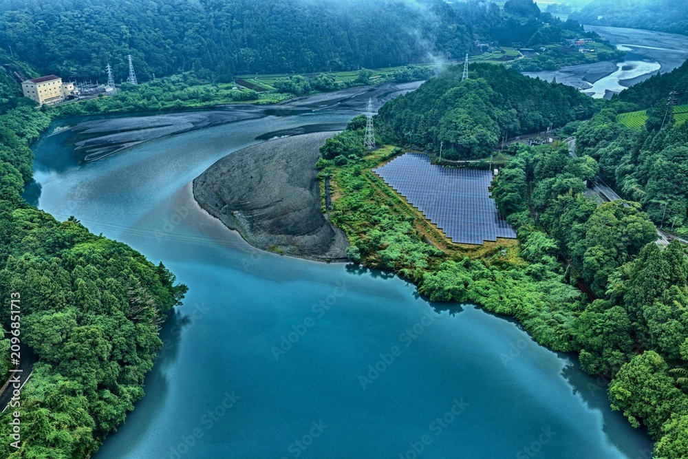Fototapeta premium Aerial drone photo of reservoir, solar panels and lush forest at sunrise in Shizuoka, Japan