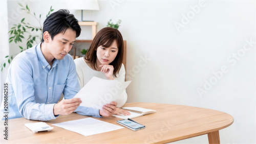 自宅で家計書類を確認し将来設計を相談する日本人夫婦