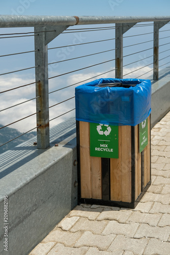 Wooden recycling waste bin with recycling symbol at a scenic mountain viewpoint in Turkey. Eco-friendly waste management in a popular tourist destination with panoramic mountain landscape