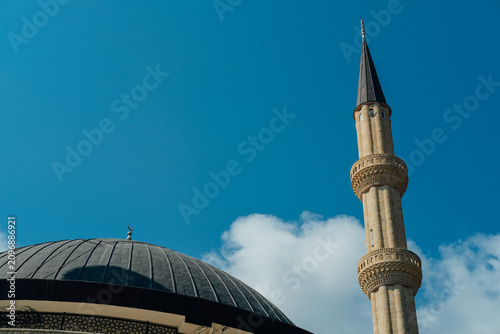 Exterior view of the Kemer Central Mosque with Minarets featuring its large dome and twin minarets against a clear blue sky in the resort town of Kemer, Antalya Province, Turkey