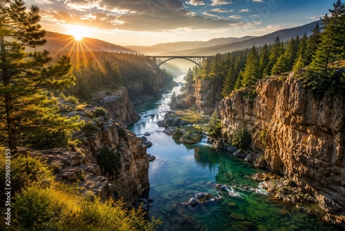 Scenic mountain river valley at sunrise with golden light. Dramatic landscape of crystal clear water flowing through lush green forest wilderness