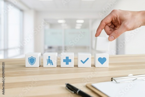 Hand stacking wooden blocks with health care and wellness icons
