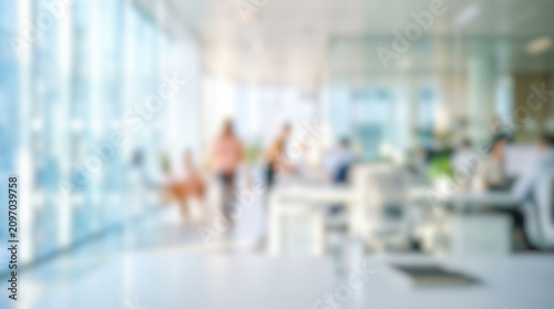 Blurred modern corporate office interior background busy business people working bright daylight soft bokeh glass walls spacious contemporary workplace environment