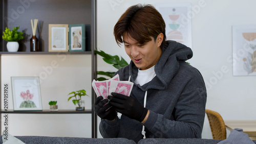 Canvastavla Excited Asian Man in Grey Hoodie Counting Cash with Black Gloves