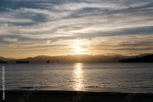 фотографія Golden sun dips over calm waters