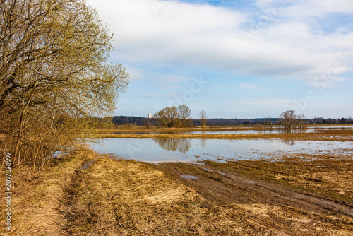 Konstfotografi Widespread spring floodwaters inundate golden lowland fields under a bright blue