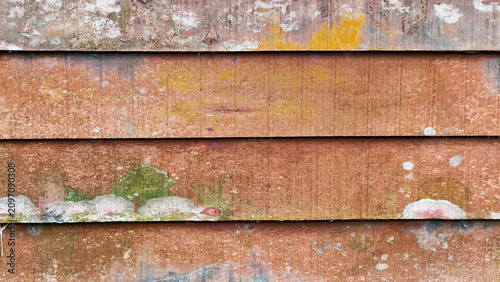 Weathered Wooden Siding Texture: Close-up of aged wooden siding revealing a textured surface with peeling paint, moss, and lichen, showcasing the beauty of decay and natural weathering.