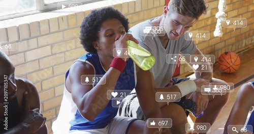 Drinking player in blue jersey sipping on break on gym bench with green bottle, social overlays