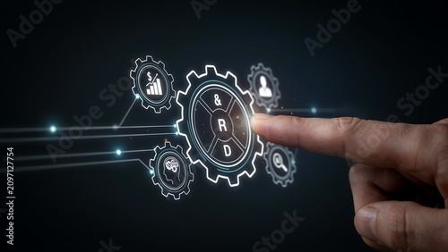 A person touches a glowing digital gear with r and d text surrounded by business symbols for research and development on dark background