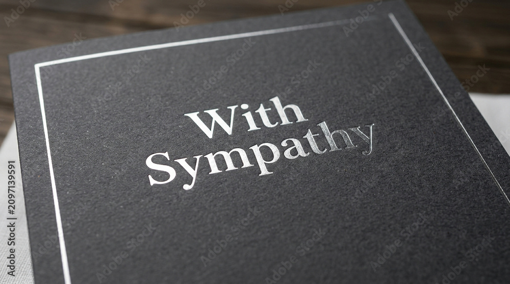 Fototapeta premium Elegant sympathy card with silver foil text, black textured funeral greeting card, condolence message on dark paper, mourning stationery