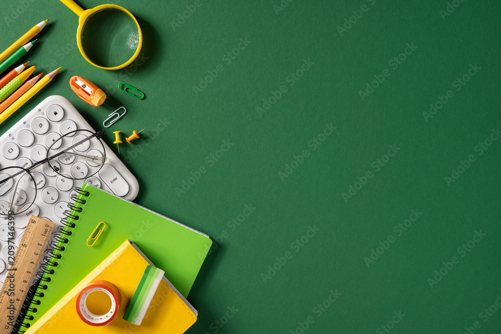 Obraz premium Back to school flat lay with green notebooks, pencils, keyboard and glasses on dark green background