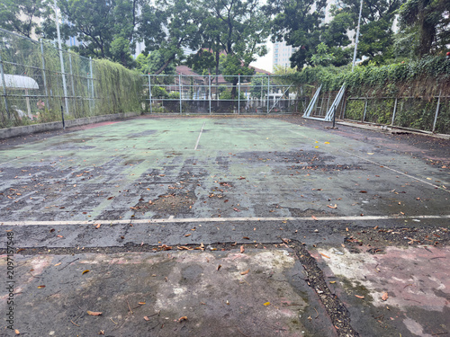 Fotografie Abandoned tennis court with cracked surface, faded lines, and neglected surroundings, reflecting the passage of time and decay