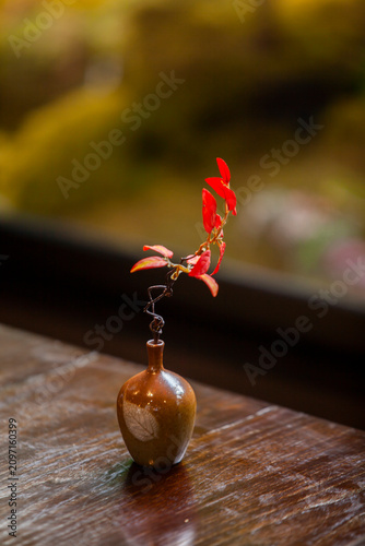 A Japanese vase with red leaves creates a warm and inviting atmosphere.