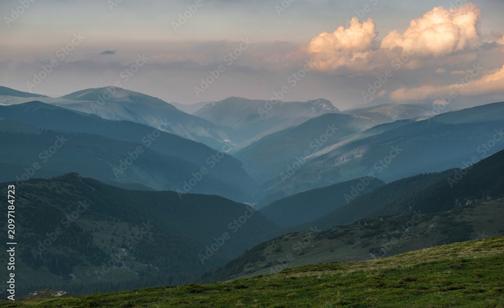 Fototapeta premium view on hills and carpathian mountains at the evening under cloudy sky summit in Romania