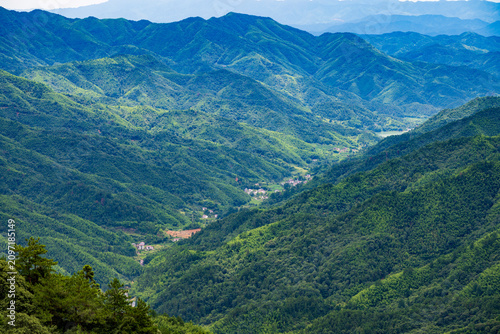 Fotografía Layered green mountain valley scenery at Huangyangjie, Jinggangshan, distant vil