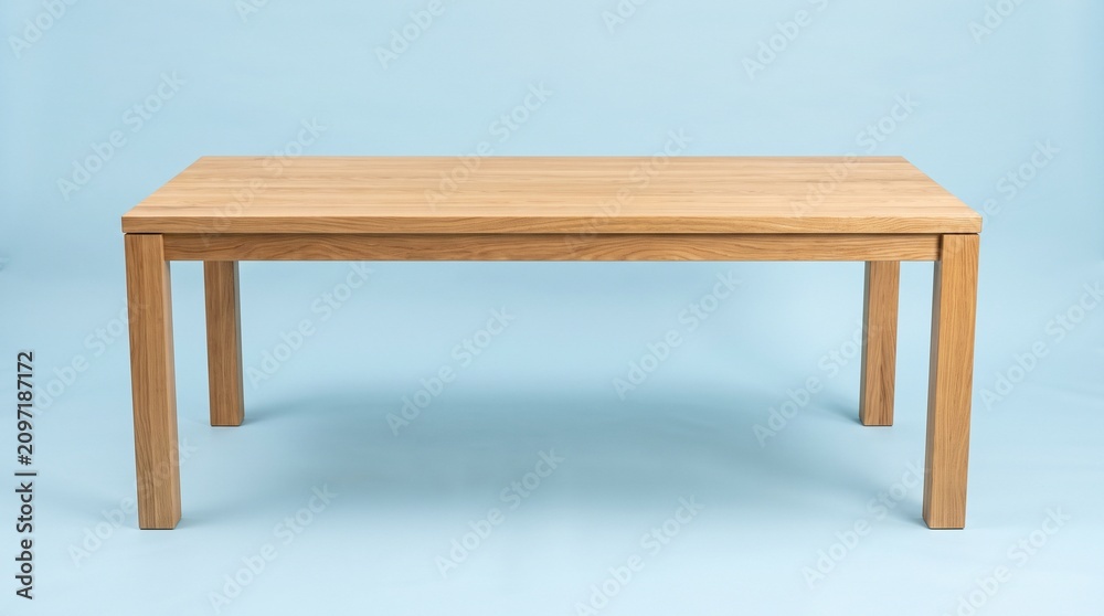 Fototapeta premium Minimalist rectangular wooden dining table made of light oak, featuring clean lines and a modern design, isolated against a solid light blue background.