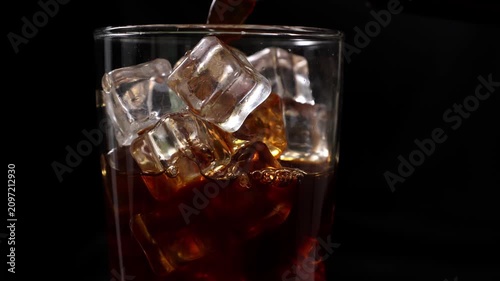 Pouring iced coffee into a glass with ice cubes
