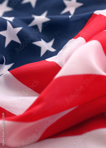 Official flag of United States of America with folds and waves close up. Patriotic background