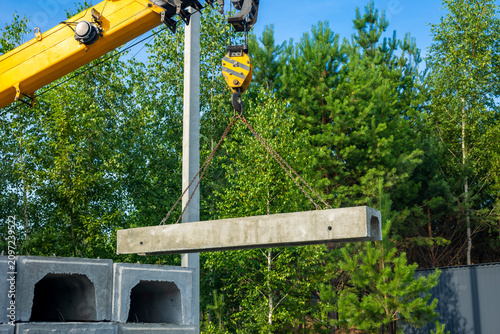 Fotografía Crane truck unloads precast concrete channel outdoors
