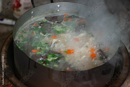 Quadro su tela Steaming hot pot of traditional Vietnamese rice porridge with pork blood pudding