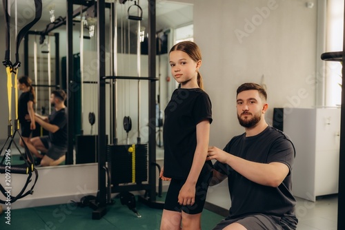 Fotografie Child receiving corrective physical therapy from a male trainer