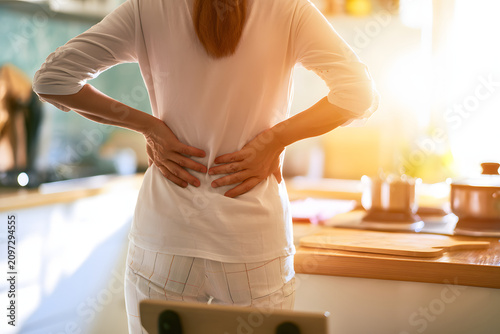 Naklejka 腰痛に悩む女性 キッチンで感じる腰の痛みと健康問題