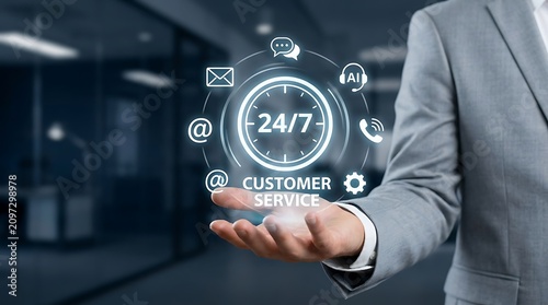 Professional businessman holding glowing holographic twenty four seven customer service interface for digital support and business communication in office